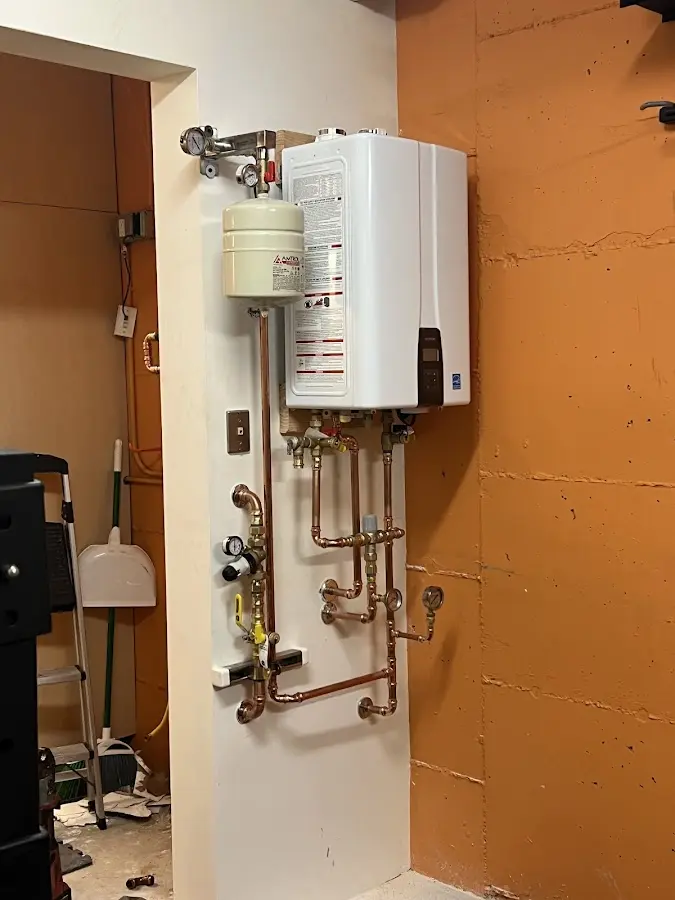 Plumbing technician inspecting water heater connections in Grandview